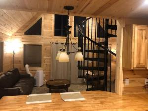 a living room with a black staircase in a cabin at Cozy 1 bedroom cabin in the heart of Jonesborough in Jonesborough
