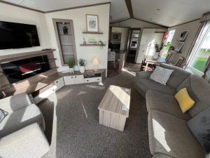 a living room with two couches and a tv at Fulmar 16, Scratby - California Cliffs, Parkdean, sleeps 6, pet friendly - 2 minutes from the beach! in Scratby