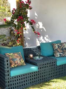 un sofá azul sentado en un patio con flores en CASA DOM QUIXOTE, pequena Chácara no centro da cidade en Atibaia