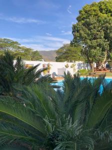 a view of a resort with a pool and trees at CASA DOM QUIXOTE, pequena Chácara no centro da cidade in Atibaia