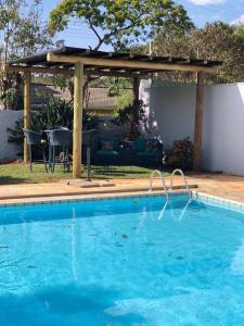 una piscina con cenador en un patio en CASA DOM QUIXOTE, pequena Chácara no centro da cidade en Atibaia