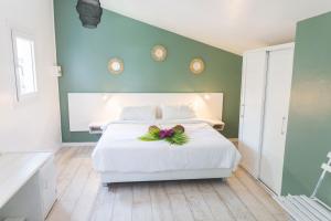 a bedroom with a white bed with a bow on it at Ilet du Lagon in La Saline les Bains