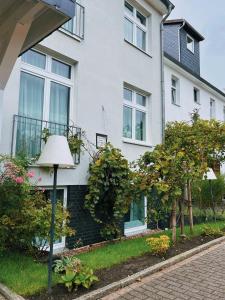 a white house with a lamp in front of it at Boutique Hotel VIVA CREATIVO in Hannover