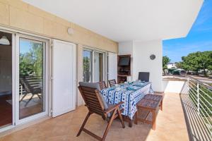 uma sala de jantar com uma mesa e cadeiras numa varanda em Santa Luzia Apartment Sl005 em Tavira