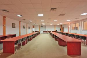 Hotel Karkonosze في كارباش: قاعة محاضرات مع صفوف من الطاولات والكراسي