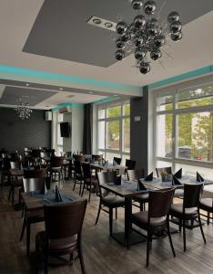 Boutique Hotel VIVA CREATIVO في هانوفر: غرفة طعام بها طاولات وكراسي وثريا