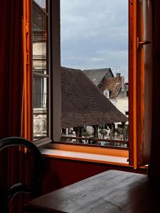 otwarte okno z widokiem na budynek w obiekcie Centre historique de LYONS LA FORET Hotel de Maître le Cottage w mieście Lyons-la-Forêt