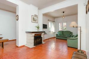 a living room with a fireplace and a green couch at Villa Praia Nova in Almada