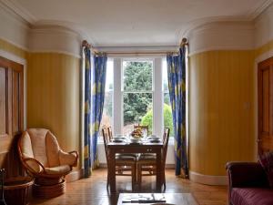 a dining room with a table and a window at Dallas Brae in Grantown on Spey