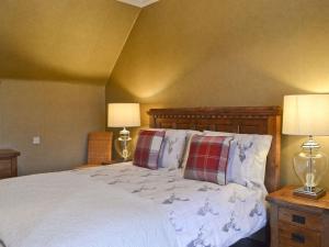 a bedroom with a bed with pillows and two lamps at Dallas Brae in Grantown on Spey