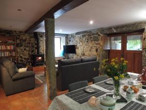 a living room with a table and chairs and a fireplace at Quinta da Tapada in Longos