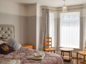 a bedroom with a bed and a chair and a window at The Terrace in Great Yarmouth