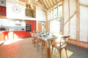 a dining room with a table and chairs in a kitchen at Yew Tree Farm Barn, Worlingworth in Worlingworth