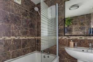 a bathroom with a tub and a sink at Hill Top in Bradford +17 photos