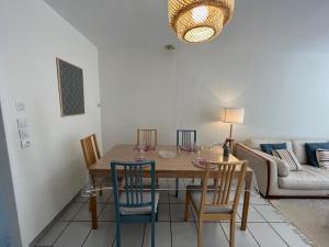 uma sala de jantar com uma mesa e cadeiras e um sofá em Calypso YourHostHelper em Ouistreham