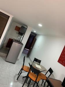 - une cuisine avec une table et des chaises dans la chambre dans l'établissement APARTAESTUDIO AMOBLADO DE UN SOLO AMBIENTE- QUINTA PAREDES CORFERIAS, à Bogotá
