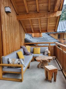 a porch with a couch and a table on a roof at LE DOMAINE DU PATRE in Vaujany