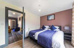 a bedroom with a large bed with blue sheets at The Exquisite Harrow Gem -Parking in Harrow Weald
