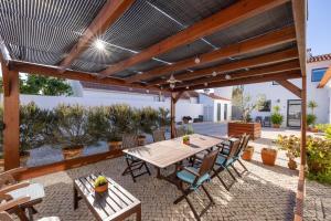 une terrasse avec une table et des chaises en bois dans l'établissement Casa Da Lagoa e Forja - Turismo Rural, à Mira