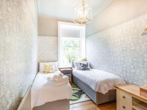 1 dormitorio con 2 camas y ventana en Carven House, en Rothbury