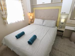 1 dormitorio con 1 cama con 2 almohadas azules en Lushness Lodge en Morpeth