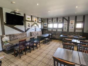 un restaurante con mesas y sillas y un bar en Lushness Lodge en Morpeth