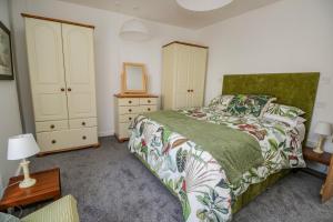 a bedroom with a bed and a dresser and a mirror at 3 Clarks Terrace in Maryport +5 photos