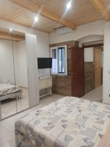 a bedroom with a large bed and a television at Al Vicoletto in Taranto