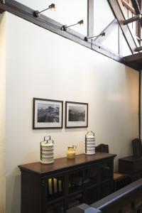 a table in a room with two pictures on the wall at Baan Luang Rajamaitri Historic Inn in Chanthaburi