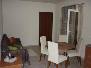 uma sala de estar com uma mesa e um sofá em Apartments Maslina em Sukošan