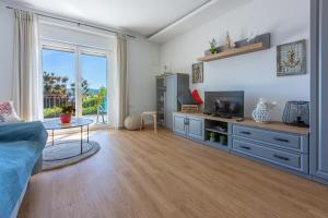 a living room with a blue couch and a tv at Apartments Milica in Crikvenica