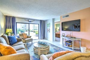 een woonkamer met een bank en een tv bij Cape Canaveral Condo with Direct Beach Access! in Cape Canaveral