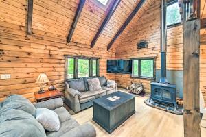 ein Wohnzimmer mit einem Sofa und einem Herd in der Unterkunft Log Cabin 9 Mi to Plattekill and Belleayre Mtn in Denver