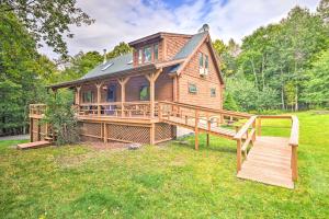 ein großes Holzhaus mit einer großen Terrasse in der Unterkunft Log Cabin 9 Mi to Plattekill and Belleayre Mtn in Denver