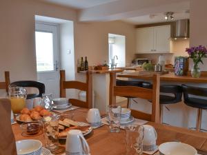 a kitchen with a wooden table with food on it at Rhosydd Cottage in Llanerchymedd