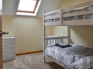 a bedroom with bunk beds and a window at Rhosydd Cottage in Llanerchymedd