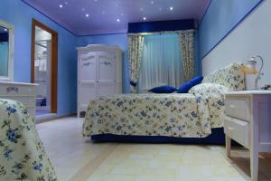 a bedroom with blue walls and a bed and chairs at Villa Delle Camelie in Gragnano
