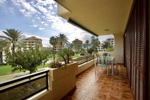 Habitación con balcón con mesa y sillas. en Apartamento Primera Linea Urb Playa Grande, en Denia