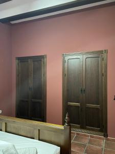 Dois armários de madeira num quarto com paredes cor-de-rosa em Casa Los pinceles de Murillo em Lora del Río