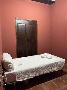 uma cama num quarto com uma parede vermelha em Casa Los pinceles de Murillo em Lora del Río