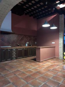 uma cozinha vazia com armários castanhos e duas luzes em Casa Los pinceles de Murillo em Lora del Río