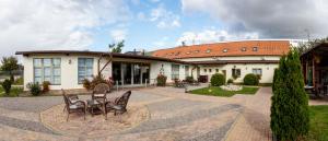 a house with two chairs and a table in front of it at HERMITAGE by Elenis in Sfântu-Gheorghe