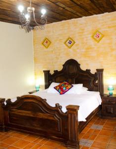 Hotel El Mirador Anexo 1 في Santa Lucía Milpas Altas: غرفة نوم مع سرير خشبي كبير في غرفة