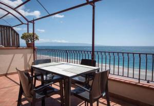 a table and chairs on a balcony with a view of the ocean at B&B La Sirena in Santa Teresa di Riva