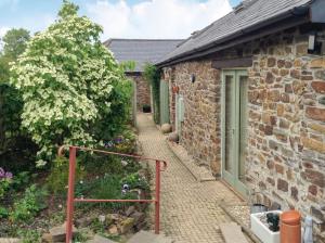 a brick house with a walkway leading to a garden at Church Barn in North Petherwin
