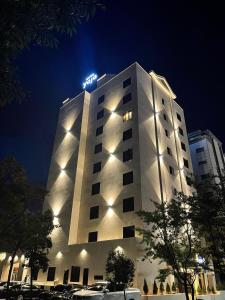 木浦的住宿－Hotel Yaja Mokpo Peace Square，一座高大的白色建筑,上面有灯