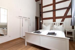 a bedroom with a white bed and a mirror at Ferienwohnung Mars in Quedlinburg
