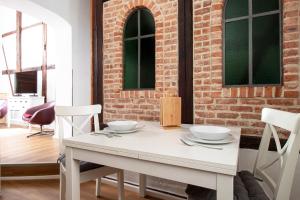 a white table and chairs in a room with a brick wall at Ferienwohnung Mars in Quedlinburg +5 photos