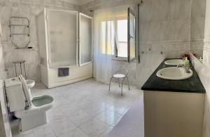 een witte badkamer met 2 wastafels en een spiegel bij DMCharme in Ponta Delgada