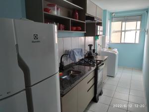 uma cozinha com um frigorífico branco e um lavatório em Apto em Curitiba perto de tudo em Curitiba